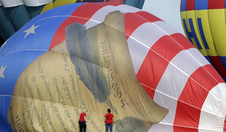 Women help deflate a balloon with a painting of the United States Constitution during the first day of the QuickChek New Jersey Festival of Ballooning, Friday, July 28, 2017, in Readington Township, N.J. (AP Photo/Julio Cortez)