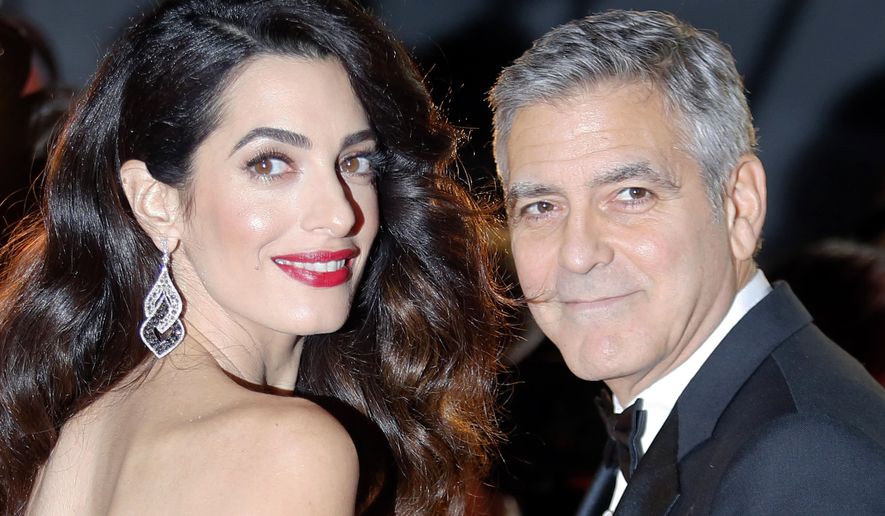 FILE - In this Feb. 24, 2017, file photo actor George Clooney and Amal Clooney arrive at the 42nd Cesar Film Awards ceremony at Salle Pleyel in Paris. George Clooney said in a statement on July 28, 2017, that photographers who captured images of him and his wife, human rights lawyer Amal Clooney, cradling their newborn twins will be “prosecuted to the fullest extent of the law.” (AP Photo/Francois Mori, File)