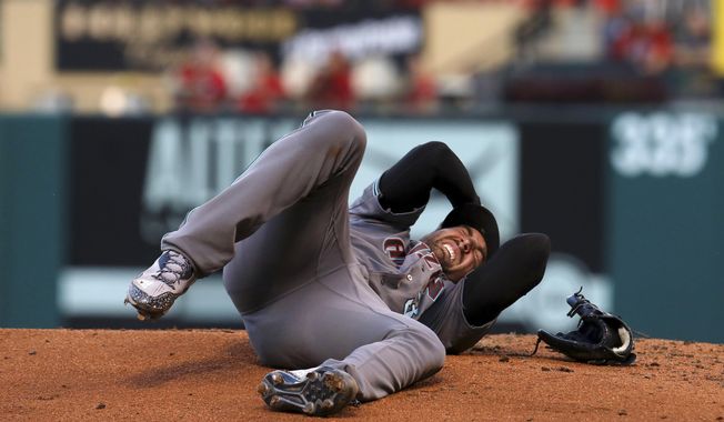 Arizona Diamondbacks pitcher Robbie Ray writhes in pain Friday, July 28, 2017, after getting hit on the head by a ball hit by St. Louis Cardinals&#x27; Luke Voit during the second inning of a baseball game in St. Louis. Ray left the game. (Christian Gooden/St. Louis Post-Dispatch via AP)