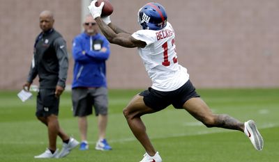New York Giants wide receiver Odell Beckham, right, makes a catch as general manager Jerry Reese, left, looks on during NFL football training camp, Saturday, July 29, 2017, in East Rutherford, N.J. (AP Photo/Julio Cortez)