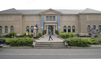 In this Wednesday, July 12, 2017 photo, a pedestrian walks past the Berkshire Museum in Pittsfield, Mass. The museum has come under intense national and local pressure after announcing earlier in the month that it is selling 40 works of art, including two by Normal Rockwell, the illustrator who called the region home for the last 30-plus years of his life. (Ben Garver/The Berkshire Eagle via AP)