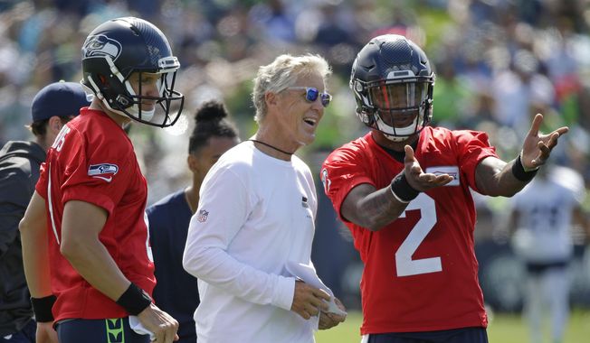 Seattle Seahawks head coach Pete Carroll, center, talks with backup quarterbacks Austin Davis, left, and Trevone Boykin, right, on the first day an NFL football training camp, Sunday, July 30, 2017, in Renton, Wash. (AP Photo/Ted S. Warren) ** FILE **