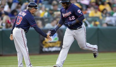 Minnesota Twins&#x27; Miguel Sano (22) shakes hands with third base coach Gene Glynn after hitting a two-run home run off Oakland Athletics&#x27; Chris Smith during the fifth inning of a baseball game on Saturday, July 29, 2017, in Oakland, Calif. (AP Photo/D. Ross Cameron)
