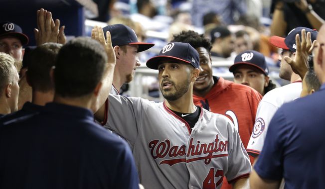 Washington Nationals starting pitcher Gio Gonzalez is high-fived in the dugout after being relieved during the ninth inning of a baseball game against the Miami Marlins, Monday, July 31, 2017, in Miami. The Nationals won 1-0. Gonzalez gave up a single to Miami Marlins second baseman Dee Gordon in the ninth inning to end his bid for a no-hitter. (AP Photo/Lynne Sladky)