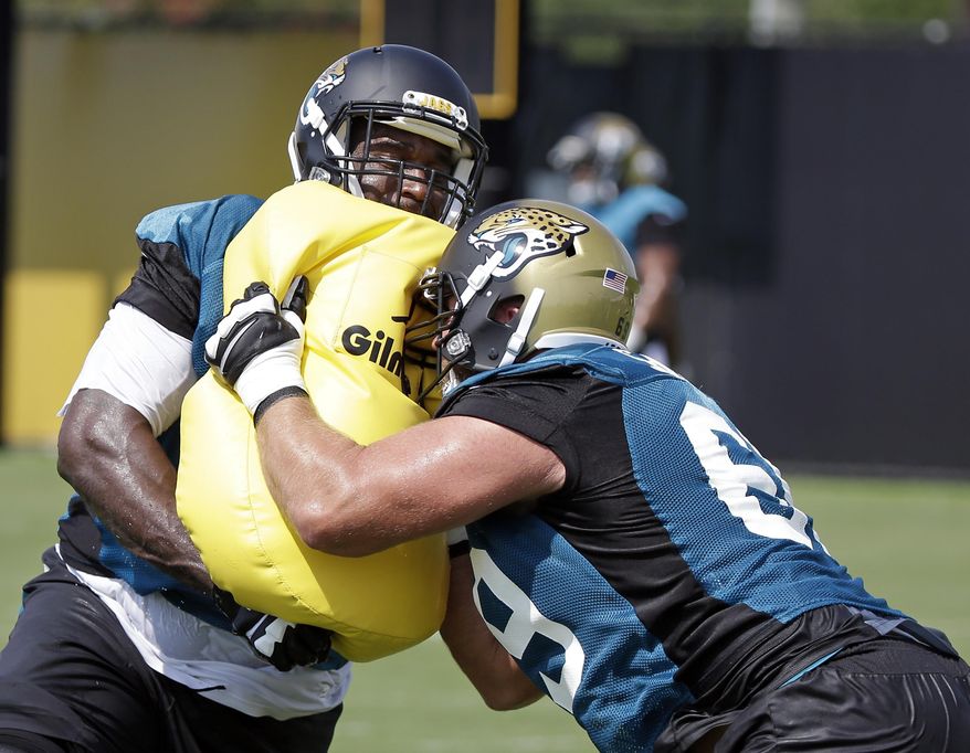 Jacksonville Jaguars offensive linemen Branden Albert, left, and Tyler Shatley, right, perform a drill during NFL football training camp, Friday, July 28, 2017, in Jacksonville, Fla. (AP Photo/John Raoux)