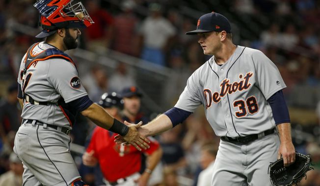 FILE - In this July 21, 2017, file photo, Detroit Tigers catcher Alex Avila and relief pitcher Justin Wilson celebrate the team&#x27;s 6-3 win over the Minnesota Twins,  in a baseball game in Minneapolis. The rolling Chicago Cubs got a big lift Monday, July 31, 2017, when they acquired reliever Justin Wilson and catcher Alex Avila in a trade with the Detroit Tigers, bolstering their chance for another long playoff run. (AP Photo/Bruce Kluckhohn, File)