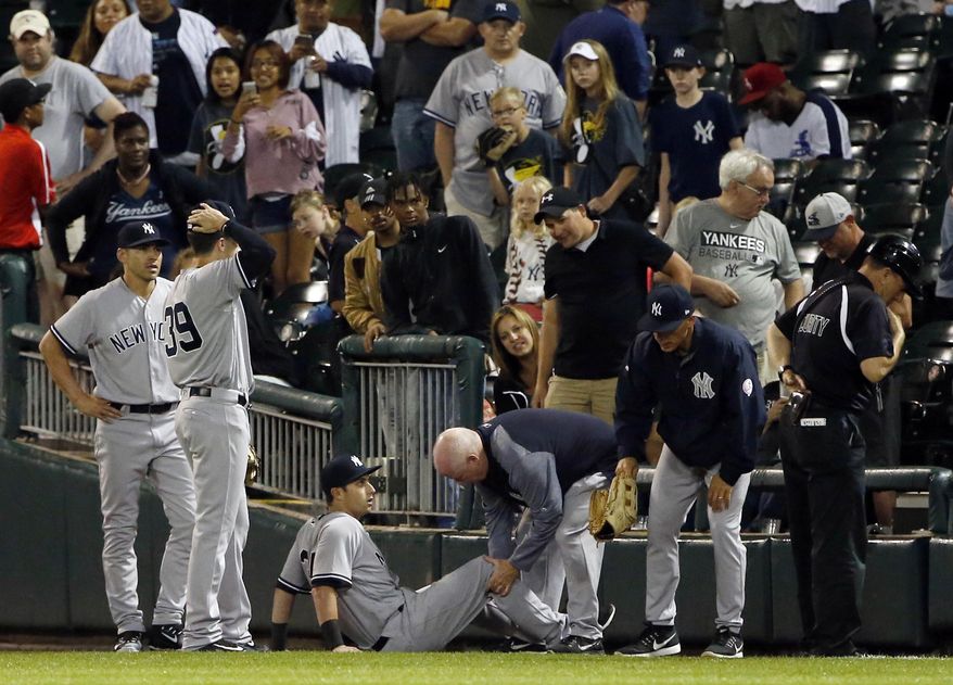 FILE - In this June 29, 2017, file photo, New York Yankees' Dustin Fowler is checked by a team trainer after an injury during the first inning of the team's baseball game against the Chicago White Sox in Chicago. The Oakland Athletics' likely center fielder of the future didn't know anybody Tuesday, a day after being traded by the Yankees in the deal that sent Sonny Gray to New York. As Gray's news conference in the Bronx showed on the A's clubhouse TV with his former teammates tuning in, Fowler discussed his own journey West. (AP Photo/Nam Y. Huh, File)