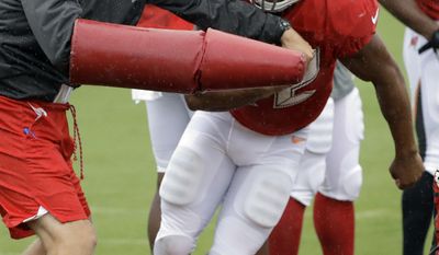 Tampa Bay Buccaneers running back Doug Martin (22) jumps over obstacles as he is hit with pads during an NFL football training camp practice Monday, July 31, 2017, in Tampa, Fla. (AP Photo/Chris O'Meara)