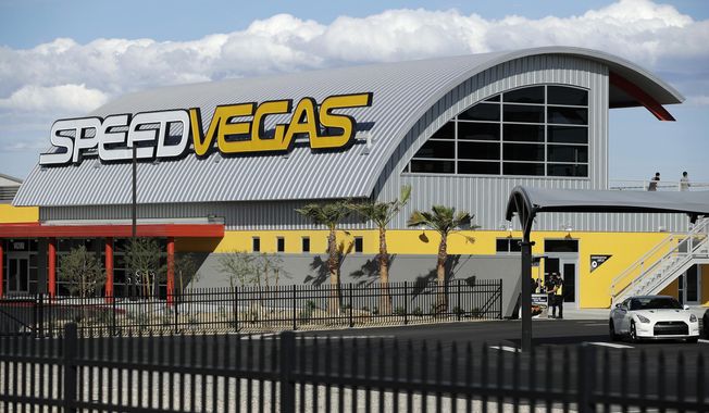 FILE - In this March 21, 2017, file photo, people stand outside of SpeedVegas in Las Vegas. Nevada safety officials are recommending fines of $16,000 against the tourist-oriented exotic auto track where a Canadian man and an instructor died in a fiery crash of a high-performance Lamborghini in February. The state Occupational Safety and Health Administration said SpeedVegas had a substandard fire and safety plan and failed to properly train employees in fire suppression. (AP Photo/John Locher, File)
