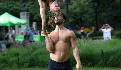 This undated photo provided by Peter Cooper shows Mike Aidala and Chelsey Khorus working on a skill called a Figa in New York's Washington Square Park. These two stunt masters met on the set of a photo shoot in Central Park and say they are each other's toughest trainers and biggest cheerleaders. It's tempting to blow off a workout, but getting sweaty with your significant other makes a workout more fun and ups the intensity ante. (Peter Cooper via AP)