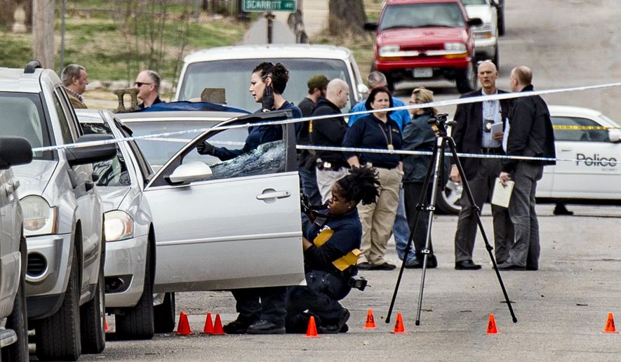 In a March 6, 2017 photo, Kansas City Police investigate a double shooting in the 100 block of North Drury Avenue in the Kansas City's northeast side that left one man dead. The city’s 86 homicides as of Monday, July 31, 2017, are 26 more than the same period in 2016 _ a year that ended with 130 murders, the most here since 1998. (Allison Long/The Kansas City Star via AP)