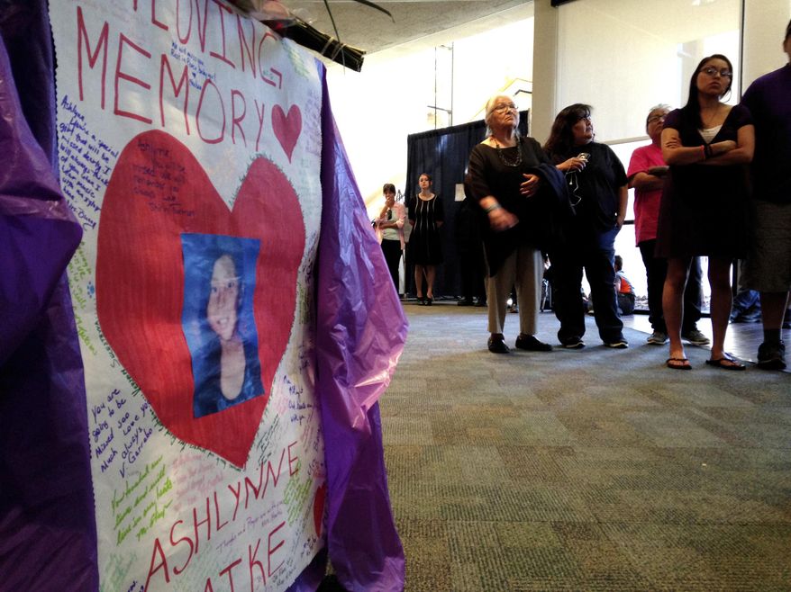 FILE - In this May 6, 2016, file photo posters with Ashlynne Mike's photo lined the entrance to the Farmington Civic Center as the overflow crowd watched monitors streaming her memorial service in Farmington, N.M. Tom Begaye, a man charged with murder, sexual assault and other counts in the death of Mike on the largest American Indian reservation changed his pleas to guilty Tuesday, Aug. 1, 2017. (AP Photo/Susan Montoya Bryan, File)