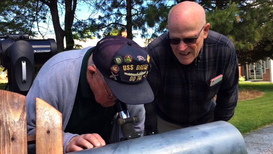 This frame grab from a video shows Gene Brick, 92, left, and his son, Bartt Brick, peer through a telescope in Madras, Ore., June 12, 2017, that they made together in 1964. The two plan to watch the upcoming solar eclipse together Aug. 21, 2017, as it passes through Oregon. (AP Photo/Gillian Flaccus)