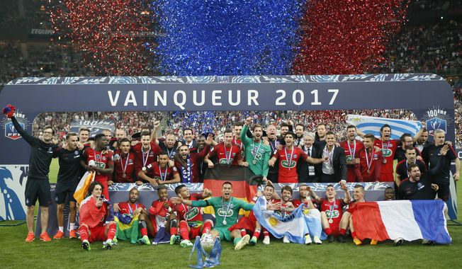 FILE - In this May 27, 2017 file photo, the Paris Saint-Germain&#x27;s team celebrate with their trophy after winning the French Cup 2017 Final soccer match, between Paris Saint-Germain (PSG) and Angers at Stade de France in Saint Denis, north of Paris, France. PSG is aiming to win the league title this season after finishing behind Monaco in the last campaign. (AP Photo/Francois Mori, File)