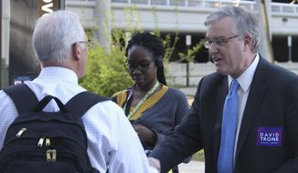 FILE - In this April 20, 2016 file photo, David Trone, right, owner of wine superstore chain Total Wine and More, greets commuters at the Shady Grove Metro station in Derwood, Md. Trone announced his candidacy Wednesday, Aug. 2, 2017, for the Democratic nomination for Maryland&#x27;s 6th District, which includes western Maryland and a large section of Montgomery County. (AP Photo/Brian Witte, File)