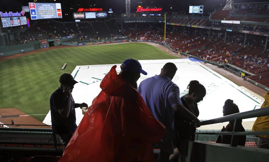 Fans leave Fenway Park after baseball game between the Boston Red Sox and Cleveland Indians was cancelled due to heavy rain and thunderstorms, after over an two hour delay, Wednesday, Aug. 2, 2017, in Boston. The game was rescheduled to Monday August 14th. (AP Photo/Charles Krupa)