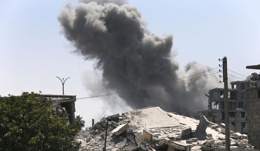 In this July 26, 2017 file photo, black smoke rises from a coalition airstrike which attacked an Islamic State militant position, on the front line on the eastern side of Raqqa, Syria. (AP Photo/Hussein Malla, File)