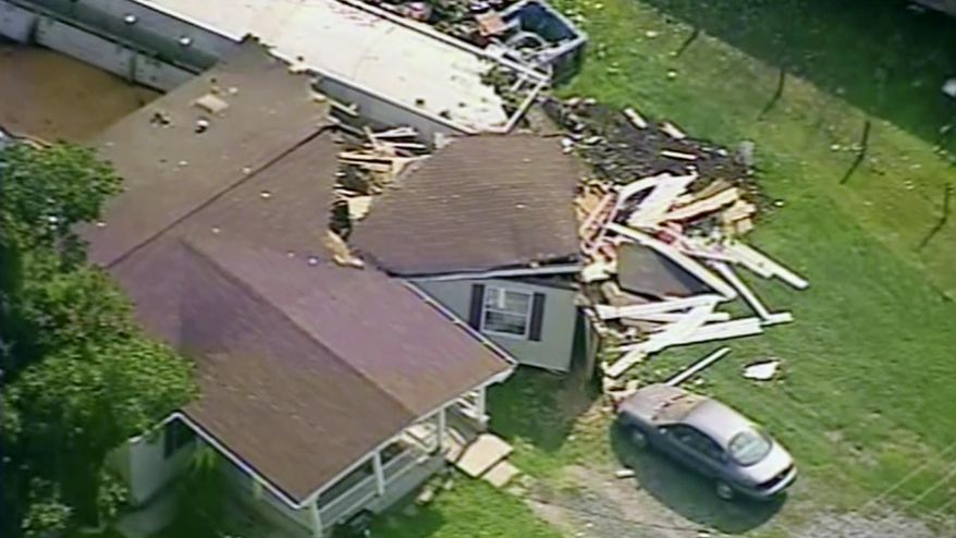 This aerial image made from a video provided by WPXI shows a damaged home after dozens of cars of a freight train carrying hazardous materials derailed in Hyndman, Pa., Wednesday, Aug. 2, 2017. County officials ordered all residents of the small Pennsylvania town to evacuate after the derailment. (WPXI via AP)