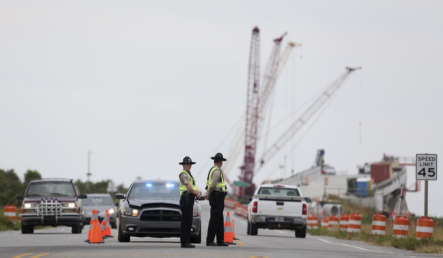 A roadblock is set up at the north end of the Bonner Bridge on Thursday, Aug. 3, 2017, on Hatteras Island, N.C. The outage caused by a construction accident forced an estimated 50,000 visitors to leave Hatteras and Ocracoke islands, and others never made it to the popular vacation spots because of evacuation orders that are still in place. (Steve Earley/The Virginian-Pilot via AP)