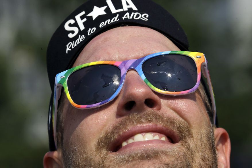 The sun is reflected in the sunglasses of Sam Dahle after he takes a cooling plunge in the Salmon Street Springs fountain before starting his job as a bartender in Portland, Ore., Thursday, Aug. 3, 2017. The National Weather Service issued an excessive heat warning for western Washington and Oregon Thursday. (AP Photo/Don Ryan)