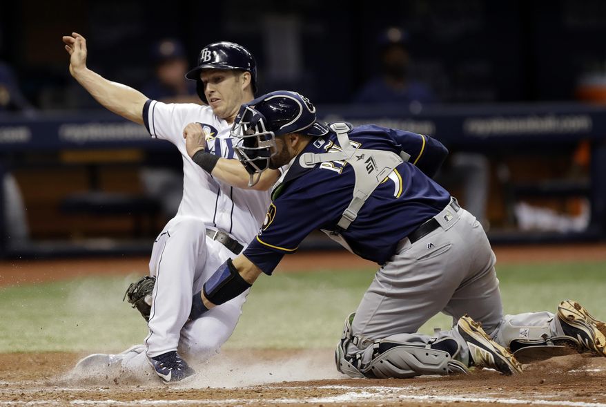Milwaukee Brewers catcher Manny Pina, right, tags out Tampa Bay Rays&#39; Corey Dickerson at home plate as Dickerson tried to score on a double by Evan Longoria during the seventh inning of a baseball game Friday, Aug. 4, 2017, in St. Petersburg, Fla. (AP Photo/Chris O&#39;Meara)
