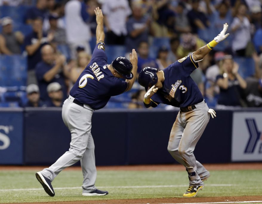 Milwaukee Brewers&#39; Orlando Arcia (3) celebrates with third base coach Ed Sedar (6) after Arcia hit a home run off Tampa Bay Rays relief pitcher Sergio Romo during the eighth inning of a baseball game Friday, Aug. 4, 2017, in St. Petersburg, Fla. (AP Photo/Chris O&#39;Meara)