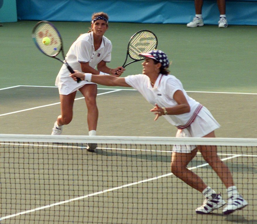 FILE - In this Aug. 3, 1996, file photo, America's doubles team of Mary Joe Fernandez, left, and Gigi Fernandez return to the Czech Republic's doubles team of Jana Novotna and Helena Sukova in the gold medal match at the Stone Mountain Tennis Center on Saturday Aug. 3, 1996, in Stone Mountain, Ga. Gigi Fernandez's prediction of taking the New York Empire to the World TeamTennis finals in her coaching debut nearly came true. The Empire lost a supertiebreaker in their last match of the season, just missing a spot in the WTT finals. Fernandez won U.S. Olympic gold in doubles with teammate Mary Joe Fernandez at the 1992 Barcelona and 1996 Atlanta Games. (AP Photo/Lynne Sladky, File)