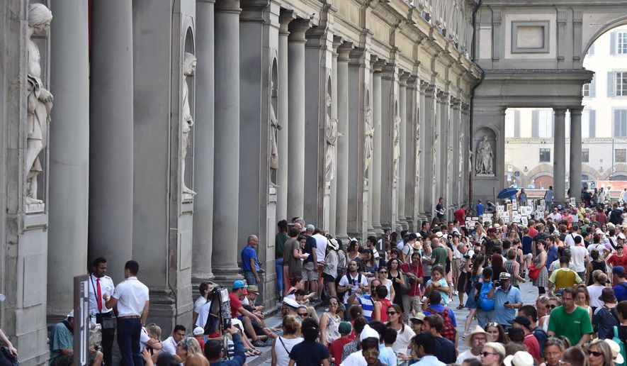 Tourists queueing to enter the Uffizi Gallery in Florence, Italy, Friday, Aug. 4, 2017. An air-conditioning breakdown has caused the Uffizi Galleries in Florence to shut its doors to the public as Italy sizzles in a heat wave. Italy’s celebrated art museum said technicians were working Friday to fix the air conditioning system so it can re-open later in the day. It was staying closed for at least three hours. (Maurizio Degl'Innocenti/ANSA via AP)