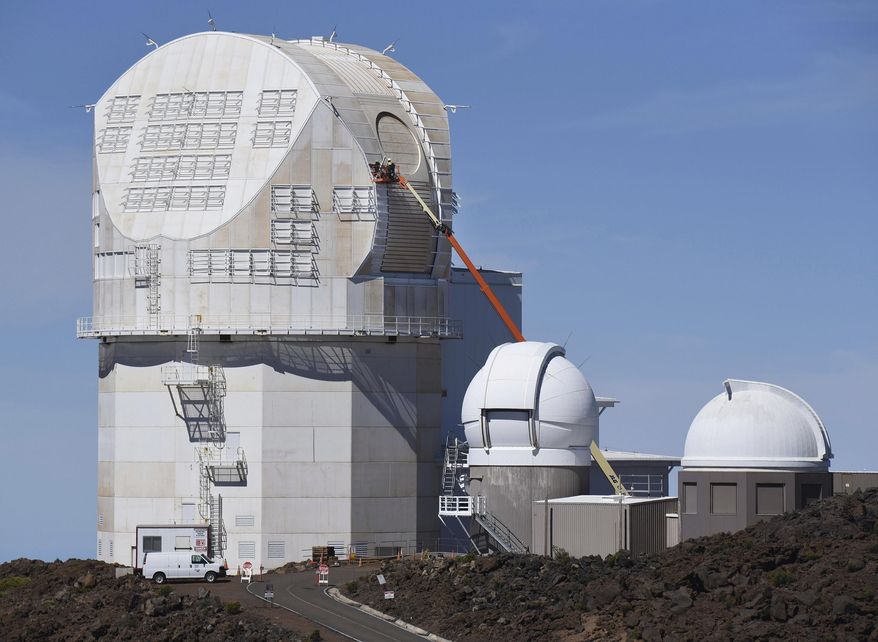 FILE - In this June 24, 2016, file photo, workers use a lift to scale the exterior the Daniel K. Inouye Solar Telescope at the summit of Haleakala in Maui, Hawaii. Five arrests were made early Wednesday, Aug. 2, 2017, when about 100 people tried to block an equipment convoy for a solar telescope being built on a Hawaii mountain held sacred by Native Hawaiians. Police say officers acted appropriately when six people were arrested while trying to block an equipment convoy from reaching a mountain where a solar telescope is being built. Some protesters who tried to block the convoy earlier this week say officers used excessive force. Police responded to the allegations Thursday, Aug. 3, 2017, saying officials have reviewed reports and video of the arrests. (Matthew Thayer/The News via AP, File)