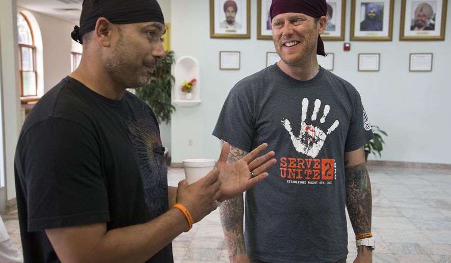 FILE - In this July 31, 2013 file photo, Pardeep Kaleka, left, and Arno Michaelis talk at the Sikh Temple of Wisconsin in Oak Creek, Wis. Five years ago on Aug. 5, 2017, a white supremacist shot and killed six temple members, including Kaleka's father, Satwant Singh Kaleka. Michaelis founded a gang of skinheads and sang in a hate-metal band but had renounced the racist movement he was a part of before the shootings. In the years since the shootings those affected by the tragedy have remained united by a mission to push back against hatred. (AP Photo/Morry Gash, File)