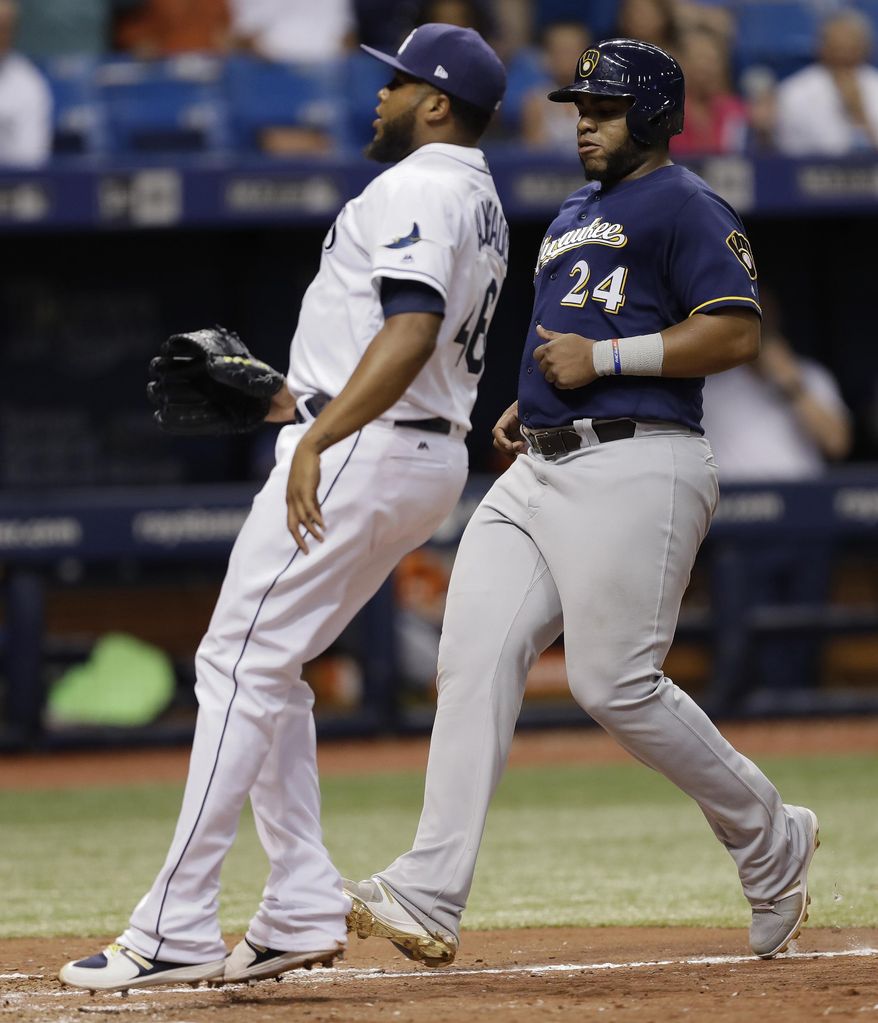 Milwaukee Brewers&#39; Jesus Aguilar (24) scores on a wild pitch by Tampa Bay Rays relief pitcher Jose Alvarado, left, during the ninth inning of a baseball game Saturday, Aug. 5, 2017, in St. Petersburg, Fla. (AP Photo/Chris O&#39;Meara)
