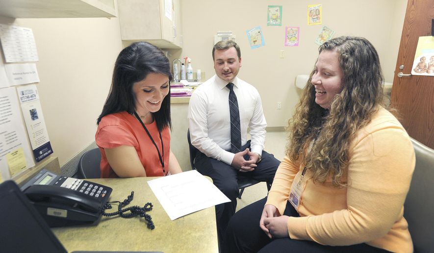 In this July 31, 2017, photo, Leah Lewis, left, and Brad Conrad, center, both WIC navigators, meet with Nutritionist Stephanie Johnson, right, as they go over WIC participation numbers inside the Green River District Health Department in Owensboro, Ky. (Alan Warren/The Messenger-Inquirer via AP)