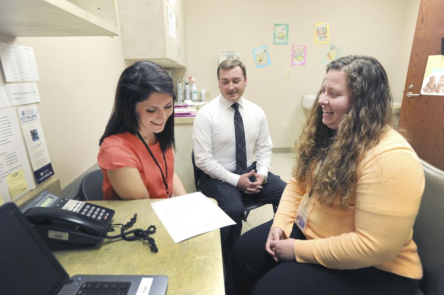 In this July 31, 2017, photo, Leah Lewis, left, and Brad Conrad, center, both WIC navigators, meet with Nutritionist Stephanie Johnson, right, as they go over WIC participation numbers inside the Green River District Health Department in Owensboro, Ky. (Alan Warren/The Messenger-Inquirer via AP)