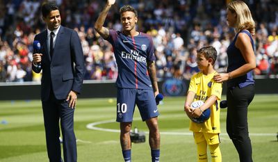 Brazilian soccer star Neymar waves to fans as he stands next to PSG president Nasser Ghanim Al-Khelaïfi at the Parc des Princes stadium in Paris, Saturday, Aug. 5, 2017, during his official presentation to fans ahead of Paris Saint-Germain&#x27;s season opening match against Amiens. Neymar would not play in the club&#x27;s season opener as the French football league did not receive the player&#x27;s international transfer certificate before Friday&#x27;s night deadline. The Brazil star became the most expensive player in soccer history after completing his blockbuster transfer from Barcelona for 222 million euros ($262 million) on Thursday. (AP Photo/Francois Mori)
