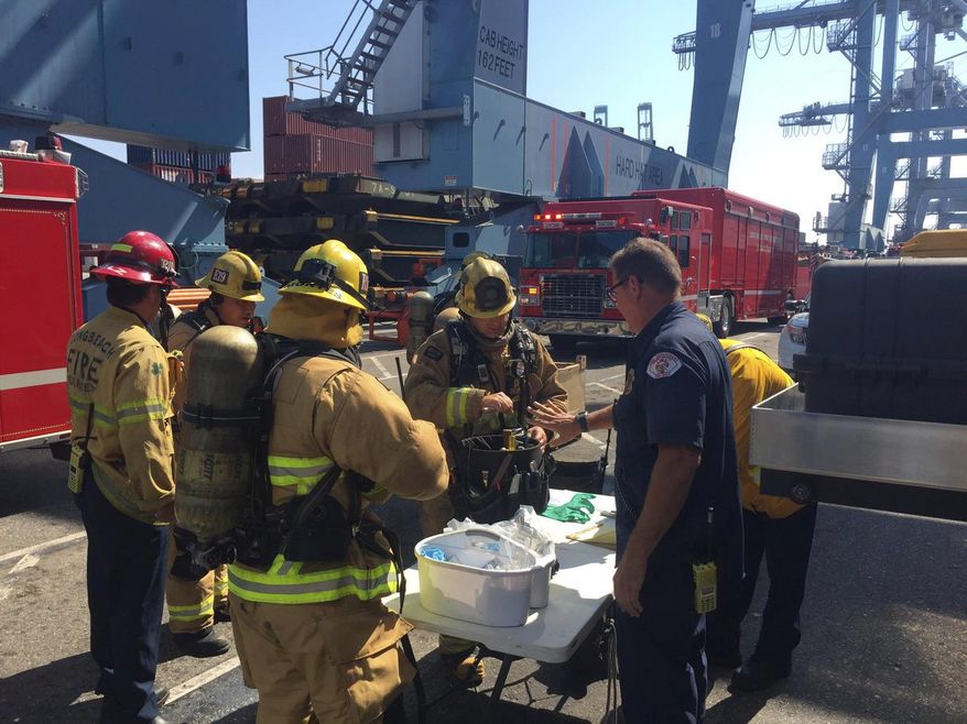 This photo courtesy of the Long Beach Fire Department shows firefighters at at Pier G, after boarding a ship in the Port of Long Beach, Calif., Sunday, Aug. 6, 2017. Long Beach firefighters treated 11 workers and one firefighter for exposure to some hazardous material fumes where a flammable liquid leaked from a 6,000 gallon tank on a container vessel. Two persons have been taken to a hospital. (Brian Fisk/Long Beach Fire Department via AP)