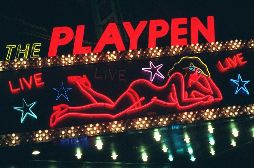 FILE - This March 6, 1998, file photo shows a detail from a neon sign above a strip club in New York's Times Square photographed after a judge concluded the city had the legal right to force most of the city's X-rated shops to relocate. New York City's two-decade legal war on storefront pornography businesses has reached a new tipping point. While many of the provocative attractions were swept out years ago - especially ones in the now neon-lit, retail-filled Times Square - the state's highest court recently issued a ruling that would force the surviving ones to clear out. (AP Photo/Michael Schmelling, File)