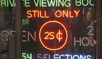 In this May 9, 2017 photo neon-lighted signs glow in the doorway of the adult store Show World Center, off 42nd Street in New York&#39;s Times Square, near the Port Authority bus terminal. New York City&#39;s two-decade legal war on storefront pornography businesses has reached a new tipping point. While many of the provocative attractions were swept out years ago - especially ones in the now neon-lit, retail-filled Times Square – the state&#39;s highest court recently issued a ruling that would force the surviving ones to clear out. (AP Photo/Bebeto Matthews)