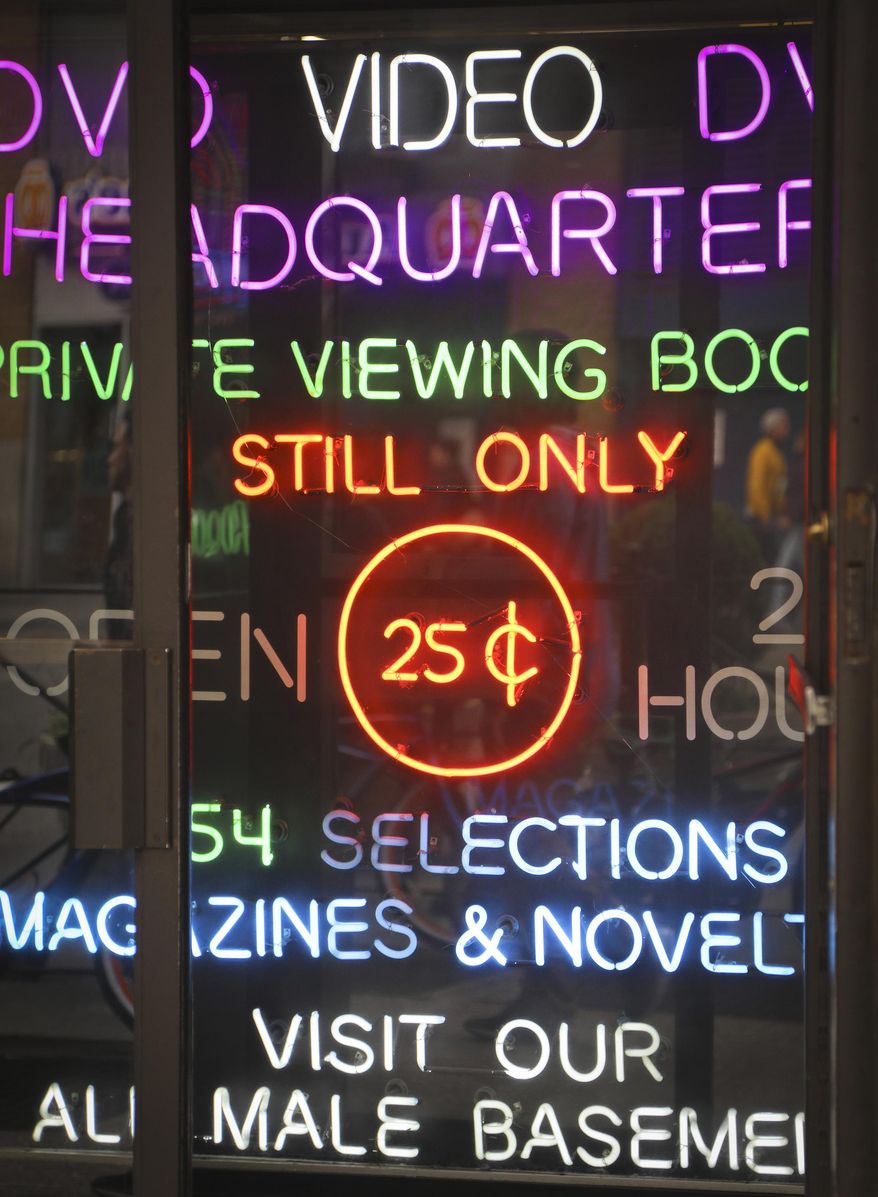 In this May 9, 2017 photo neon-lighted signs glow in the doorway of the adult store Show World Center, off 42nd Street in New York&#x27;s Times Square, near the Port Authority bus terminal. New York City&#x27;s two-decade legal war on storefront pornography businesses has reached a new tipping point. While many of the provocative attractions were swept out years ago - especially ones in the now neon-lit, retail-filled Times Square – the state&#x27;s highest court recently issued a ruling that would force the surviving ones to clear out. (AP Photo/Bebeto Matthews)