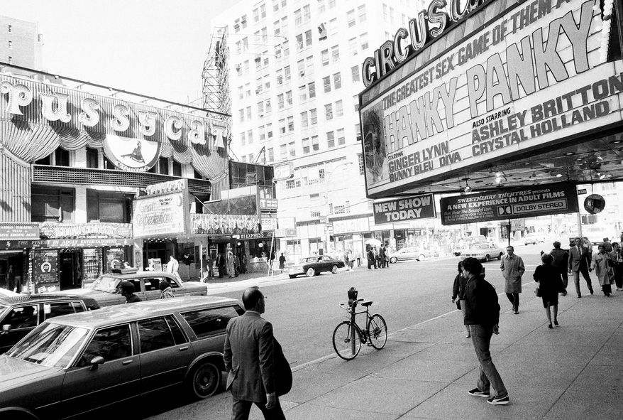 FILE - This Oct. 4, 1984 file photo shows porn shops and peep shows in New York's Times Square. New York City's two-decade legal war on storefront pornography businesses has reached a new tipping point. While many of the provocative attractions were swept out years ago - especially ones in the now neon-lit, retail-filled Times Square – the state's highest court recently issued a ruling that would force the surviving ones to clear out. (AP Photo/Mario Cabrera, File)