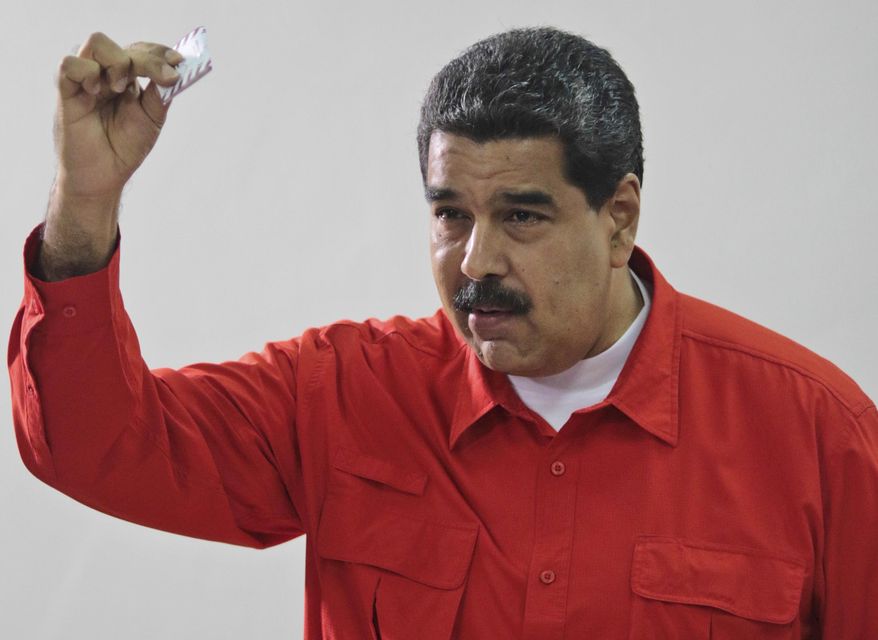 Venezuela&#x27;s President Nicolas Maduro shows his ballot after casting a vote for a constitutional assembly in Caracas, Venezuela, July 30. (Miraflores Press Office via AP) ** FILE **