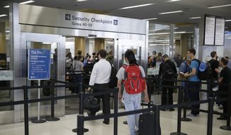 In this Wednesday, June 29, 2016, photo, a pair of travelers, at left, walk through a TSA Precheck security line, while other passengers wait in line to be screened, in Terminal 2 of San Francisco International Airport in San Francisco. Passengers at all U.S. airports will soon face new measures for screening electronic devices bigger than a cellphone. Security officers will ask travelers in regular lanes to take all larger devices out of their bag and put them in a bin by themselves, similar to the screening of most travelers laptops. Officials say it gives X-ray screeners a clearer picture of the devices. The change wont apply to Precheck lanes. (AP Photo/Eric Risberg)