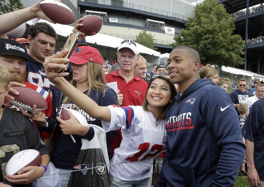Boston Celtics basketball player Isaiah Thomas, right, stands with a fan for a selfie following an NFL football joint practice with the Jacksonville Jaguars and the New England Patriots, Monday, Aug. 7, 2017, in Foxborough, Mass. (AP Photo/Steven Senne)