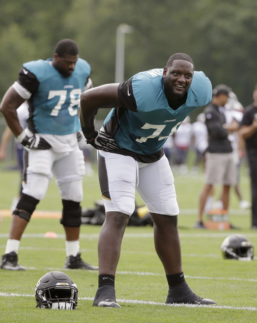 Jacksonville Jaguars offensive tackles Cam Robinson, front right, and Jermey Parnell, left, warm up during an NFL football joint practice with the New England Patriots, Monday, Aug. 7, 2017, in Foxborough, Mass. (AP Photo/Steven Senne)