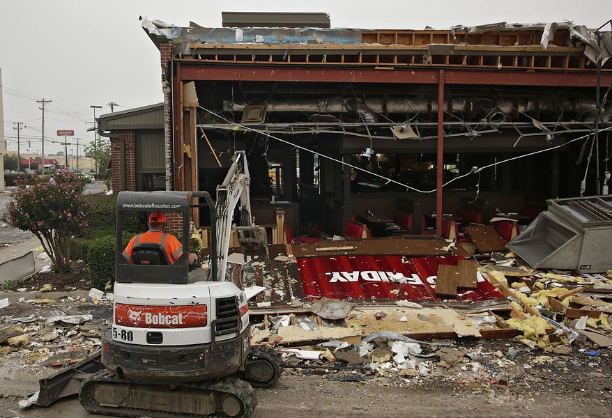 A worker clears debris from TGI Fridays in Tulsa, Okla., Monday, Aug. 7, 2017. (Mike Simons/Tulsa World via AP)