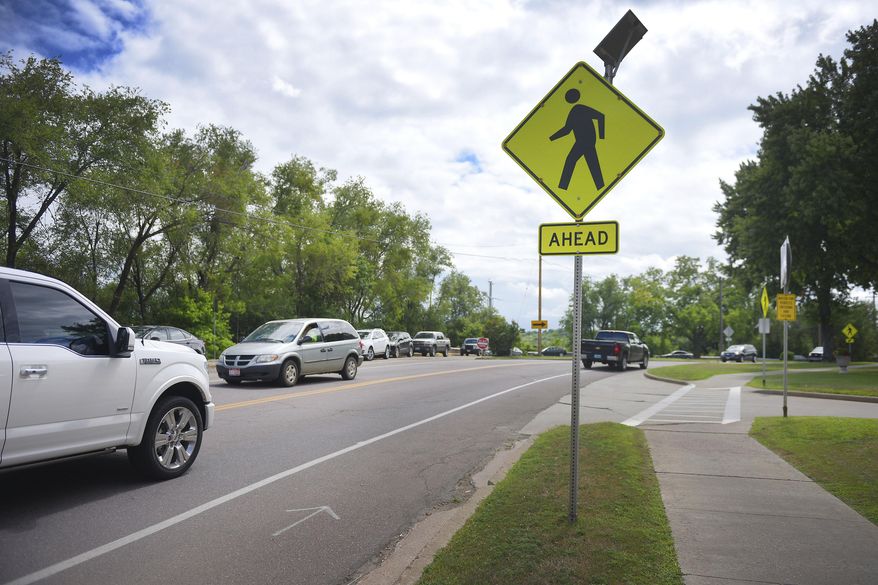 In this Aug. 3, 2017 photo, vehicles make their way on North drive in front of South Dakota State Penitentiary in Sioux Falls, S.D. High speeds and heavy traffic on the road leading to the state's largest prison have Sioux Falls and the state Department of Corrections looking at ways to improve safety. The city painted a bike lane and narrowed driving lanes along North Drive this spring and will use traffic counters to judge if speeds drop enough to create safer conditions. (Briana Sanchez/The Argus Leader via AP)