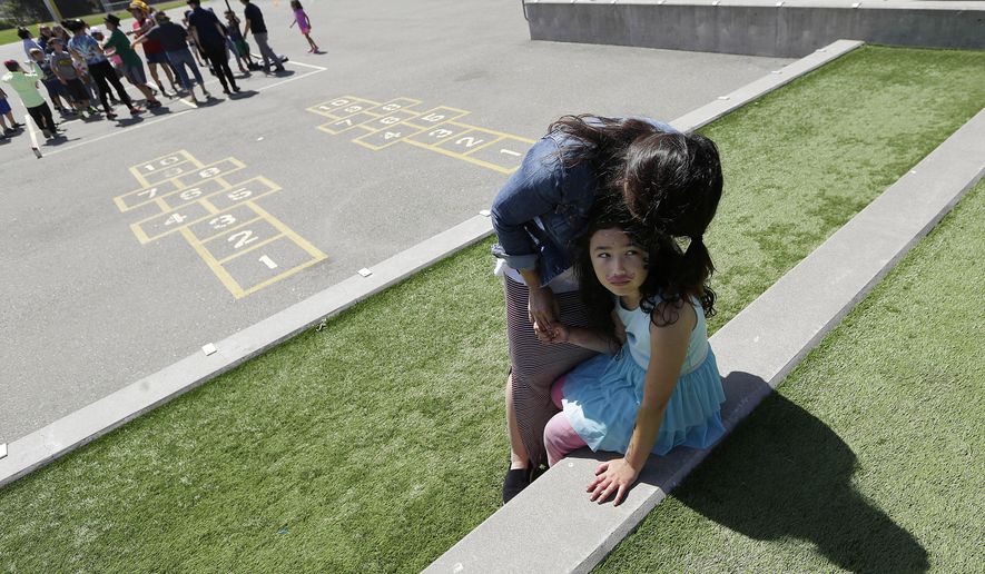In this Tuesday, July 11, 2017 photo, Sandra Collins, executive director and founder of enGender, hugs her child Scarlett at the Bay Area Rainbow Day Camp in El Cerrito, Calif. Gender experts say Rainbow’s rapid growth reflects what they’re seeing in gender clinics around the country: an increasing number of kids coming out as transgender at young ages. (AP Photo/Jeff Chiu)