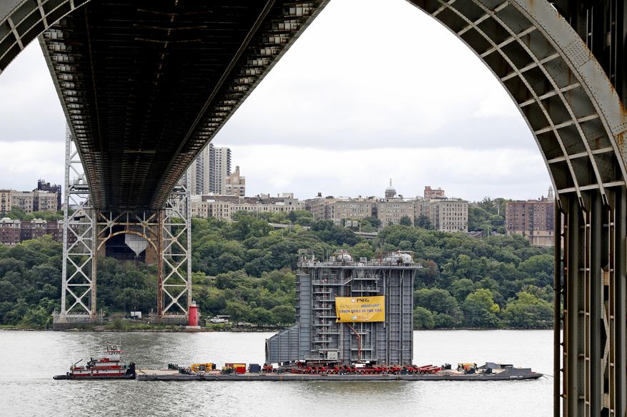 A large generator passes under the George Washington Bridge as seen from Fort Lee, N.J., Tuesday, Aug. 8, 2017. A 130-foot-(40-meter)-tall steam generator built along the Hudson River outside Albany is on a barge heading south for a New Jersey power plant. (AP Photo/Seth Wenig)