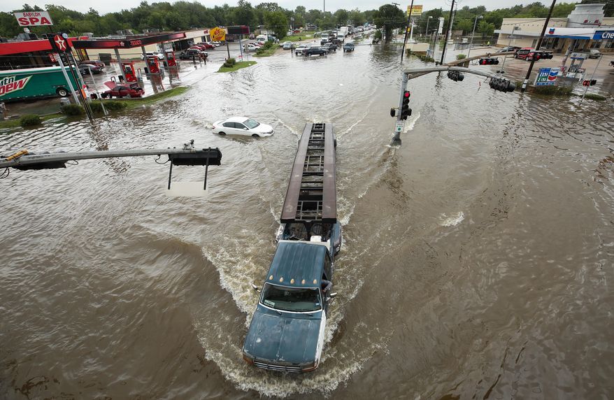 A motorists drives through floodwaters on West Mount Houston Road near Interstate 45 North, Tuesday, Aug. 8, 2017, in Houston. Torrential rains have brought more flooding to the Houston area as emergency officials urge motorists to stay home until the water recedes. (Godofredo A. Vasquez/Houston Chronicle via AP)