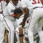 Atlanta Braves shortstop Johan Camargo is helped up by third base coach Ron Washington (37) and bench coach Terry Pendleton, left, after collapsing as he took the field before a baseball game against the Philadelphia Phillies, Tuesday, Aug. 8, 2017, in Atlanta. Jace Peterson took his place to start the game at shortstop. (AP Photo/John Amis)