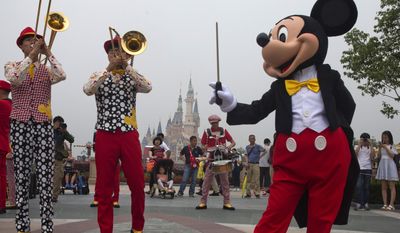 FILE - In this Thursday, June 16, 2016, file photo, Mickey Mouse entertains visitors on the opening day of the Disney Resort in Shanghai, China. The Walt Disney Co. reports earnings, Tuesday, Aug. 8, 2017. (AP Photo/Ng Han Guan, File)